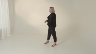 Modaya uygun bir model, şık, minimalist bir arka plana karşı çağdaş modanın en son modelini ustalıkla sergiliyor.