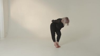 Yetenekli bir dansçı zarif bir şekilde çağdaş minimalist bir ortamda büyüleyici, akışkan hareketler sergiler.