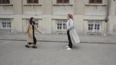 Video şehir bağlantılarını gösteriyor. Bir çift şefkat gösteriyor, iki kadın dans ediyor, arkadaşlar sohbet ediyor, sarılıyor ve tokalaşıyor.
