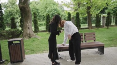 Bu video, arkadaşlarıyla etkileşim halinde olan parkta neşeli bir gün gösteriyor. İki kadın sohbet ederken, bir çift bankta gülüyor, sıcaklığı ve neşeyi yakalıyorlar.