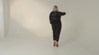 Son derece şık ve zarif bir kadın modern tarzını şık minimalist stüdyo ortamında sergiliyor.