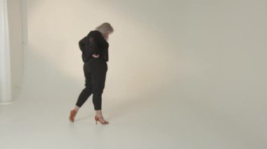 Şık bir kadın, parlak ve canlı bir stüdyo ortamında modern moda eğilimleri sergiliyor.