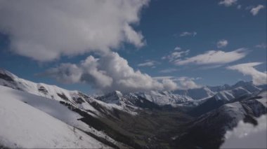 Kar kaplı dağların, engebeli vadilerin, kabarık bulutların ve açık bir günde mavi gökyüzünün nefes kesici manzarası..