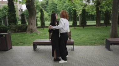 Canlı bir parkta, iki çift dansçı hareketle neşeyi ifade eder, neşeli anları yakalar ve yemyeşil alanlara karşı şefkat gösterirler.