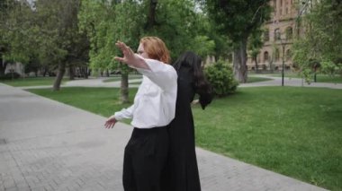 Huzurlu bir parkta, iki kadının kucaklaşması, bir çiftin kucaklaşması ve bir diğerinin doğası gereği dans etmesi de dahil olmak üzere birbirine bağlanan çiftleri gösteriyor.