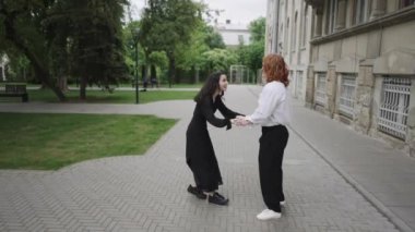 Bu video parkta bir çiftin romantik yürüyüşü, canlı bir dans ve iki kadının birliktelik ve dostluk yaydığı bir eğlence sergiliyor.