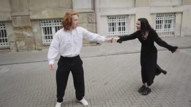 Bir çiftin kaldırımda el ele yürüdüğünü ve dans ettiğini gösteren neşeli bir video. Aşkı ve arkadaşlığı kutluyorlar.