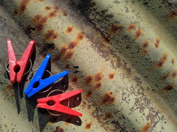 colorful clothespins on a rusty metal surface