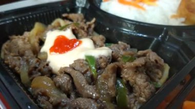 Manzaralı el yemek çubuğuyla sığır eti toplayın. Geleneksel Japon ızgara sığır eti ve soğan ve yeşil biber.
