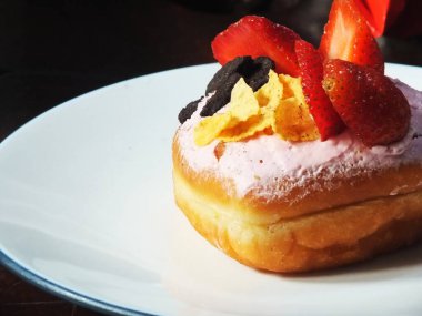 Çilekli tatlı pasta, mısır krakeri, şeker kreması. İştah açıcı siyah arkaplanda izole edilmiş. Kafe ve restoran işletmeleri için yiyecek ve içecek imajı.