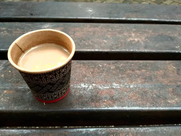 Paper Cup on Bench in Outdoor Setting, Warm Beverage in Exposable Cup on Vintage Bench, Rustic Coffee Moment Outdoor Bench 'te Paper Cup' ı kullanarak metin alıntıları için fotokopi alanı