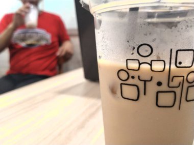 Masadaki soğuk espresso kahvesini kapat, seçici odaklanma ve bir adam arkada. Arka plan bulanık. Metin reklamı için alanı kopyala