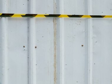 Beyaz kıvrımlı metal plaka ve güvenlik korkuluğu bandı. Uzayı metin için kopyala. Açık hava endüstrisi ve inşaat kavramı