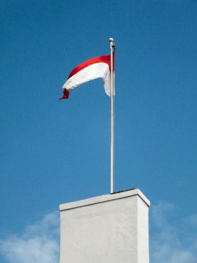 Endonezya ulusal bayrağı açık mavi arka planda rüzgarda dalgalanıyor. Vatanseverlik. Hari Kemerdekaan Endonezyası