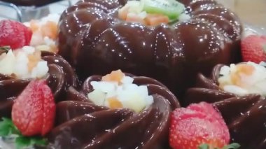 Çilek süslemeli ve kremalı çikolatalı pudingin el kamerası görüntüsü.