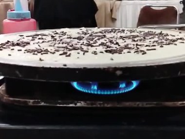 Krep pişirme sürecinde yakın plan çekim. Yavaş çekim sahnesi kızartma tavasının önünde