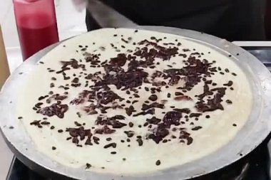 Şefin ellerinin krep yaparken yakın plan fotoğrafı. Yavaş çekim sahnesi kızartma tavasının önünde