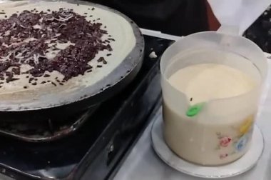 Şefin ellerinin krep yaparken yakın plan fotoğrafı. Yavaş çekim sahnesi kızartma tavasının önünde