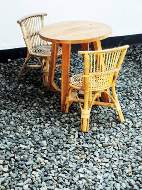 Tahta sandalye ve çakıl taşının üzerindeki masa. Dış tasarım peyzaj restoranı kahve dükkanı ya da teras. Yaz kıyı atmosferi