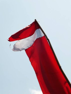 Endonezya ulusal bayrağı açık mavi arka planda rüzgarda dalgalanıyor. Vatanseverlik. Hari Kemerdekaan Endonezyası