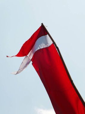 Endonezya ulusal bayrağı açık mavi arka planda rüzgarda dalgalanıyor. Vatanseverlik. Hari Kemerdekaan Endonezyası