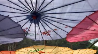 Düşük açı. Parlak gün ışığında mavi gökyüzü ile tavanda asılı renkli şemsiyeler. Turizm dekorasyonu