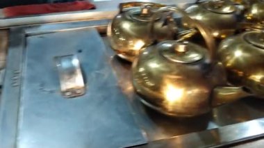 Meşgul mutfak aktivitesi, çay bardağının içine çay dökme, sanatsal arka planda hafif bir renk ve aromatik sahne gösterimi