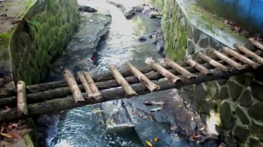 Gün boyunca açık hava parkındaki küçük bir derenin üzerindeki kırık ahşap köprü. Çevre kampanyası için görüntüler.