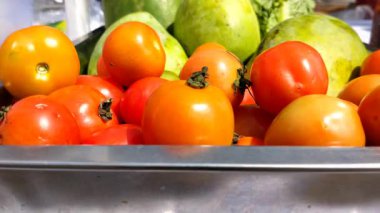 Metal bir sepette olgun mangolar ve domatesler organik meyveleri sağlıklı yiyeceklere yakın görüyorlar. Eğitim içeriği ve biyolojik çeşitlilik için taze gıda yakalama