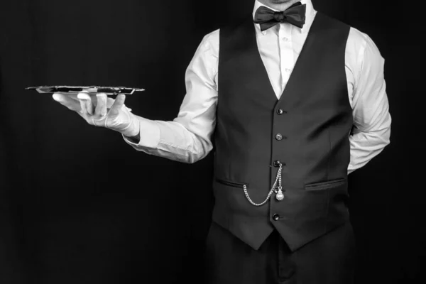 Butler or Waiter in Vest and White Gloves Holding Silver Tray. Concept of Service Industry and Professional Hospitality. Copy Space for Service and Courtesy