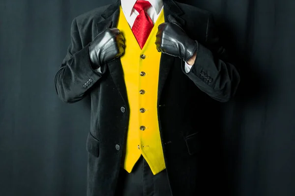 Portrait of Man in Dark Suit and Yellow Vest and Red Tie and Leather Gloves. Vintage Style and Retro Fashion