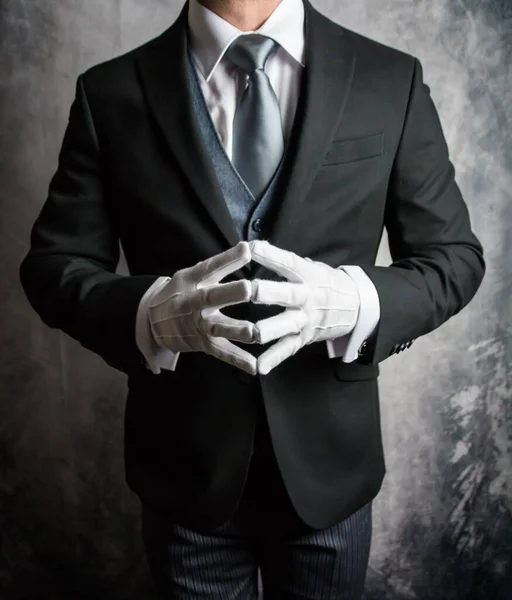 Portrait of Butler or Hotel Concierge in Dark Suit and White Gloves Eager to Be of Service. Concept of Elegant Hospitality and Professional Courtesy.