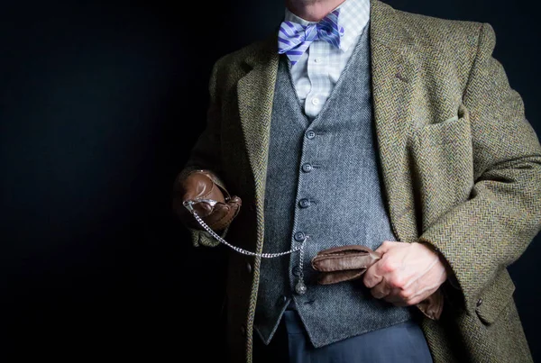 Portrait of British Gentleman in Tweed Suit and Bowler Hat Looking at Pocket Watch. Vintage Style of Classic English Gentleman.