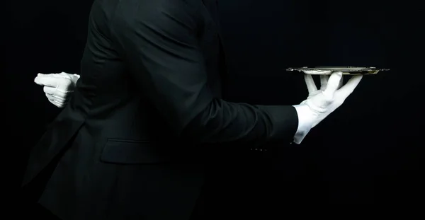 Portrait of Elegant Butler or Waiter in Dark Suit and White Gloves Holding Serving Tray. Service Industry and Professional Hospitality.