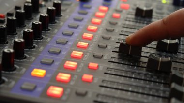 Ses kayıt stüdyosundaki mikserde ses ayarları yapılıyor. yakın plan.