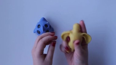 Womens hands crumple and crush rubber silicone turtle and dolphin close-up top view. Board game for the development of motor skills. Trendy toy fidget. Silicone soft stretchable toys. Antistress toy