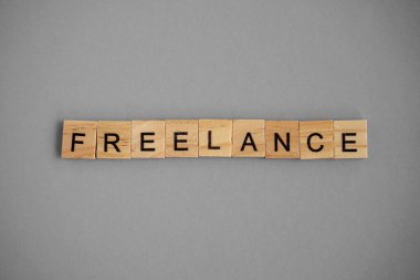 Word freelance. Wooden blocks with lettering on top of gray background. Human Resource Management and Recruitment and Hiring concept.