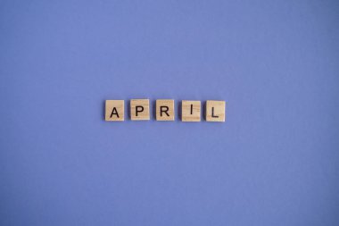 The fourth month of the year April - from individual letters on wooden bars in natural color, in high resolution. Very Peri Color of the year background, copy space. Flat lay, step by step, step 4