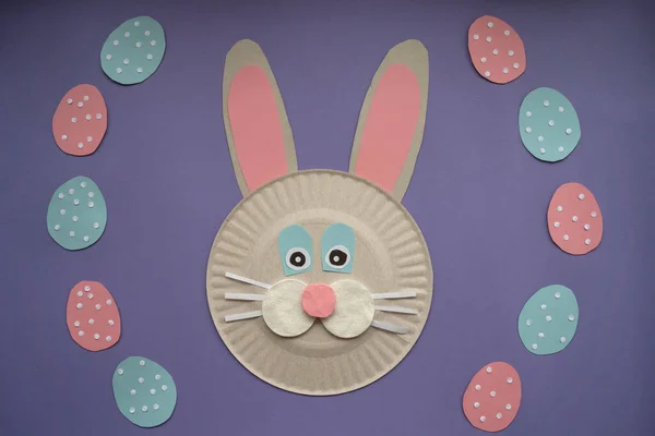 How to make paper bunny for Easter greetings. Children art project. Step by step photo instruction. DIY concept. Very Peri background color. Step 6. Decorate the eggs with paper sequins. Final