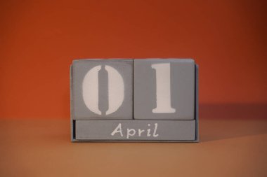 1 April on wooden grey cubes. Calendar cube date 01 April. Fools day, funny date. Concept of date. Copy space for text or event. Wood blocks in box with date, day and month. Selective focus