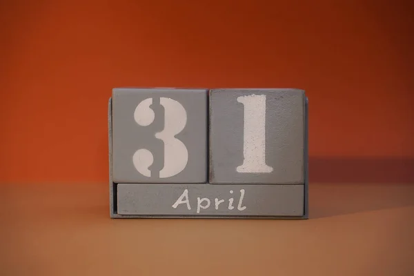 31 April on wooden grey cubes. Non-existent fantasy funny date. Concept of date. Copy space for text or event. Educational cubes. Wood blocks in box with date, day and month. Selective focus
