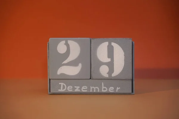 29 Dezember on wooden grey cubes. Calendar cube date 29 December. Concept of date. Copy space for text or event. Educational cubes. Wood blocks in box with german date, day and month. Selective focus