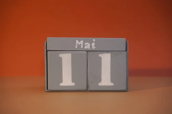 11 Mai on wooden grey cubes. Calendar cube date 11 May. Concept of date. Copy space for text or event. Educational cubes. Wood blocks in box with german date, day and month. Selective focus