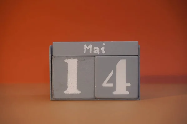 14 Mai on wooden grey cubes. Calendar cube date 14 May. Concept of date. Copy space for text or event. Educational cubes. Wood blocks in box with german date, day and month. Selective focus