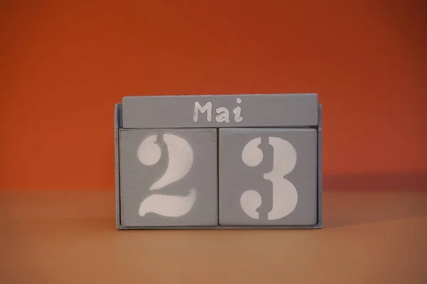 23 Mai on wooden grey cubes. Calendar cube date 23 May. Concept of date. Copy space for text or event. Educational cubes. Wood blocks in box with german date, day and month. Selective focus