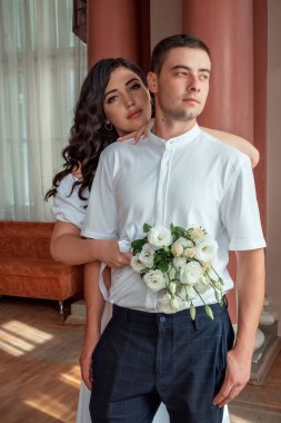 Happy,beautiful bride and groom in interior of hotel in wedding day. High quality photo