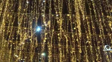 Night City. New Years garlands in the night city against the sky. Night alley with bright lanterns and stars