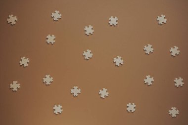 Flat wooden puzzles on brown background view from above. Festive background for a congratulatory inscription. New Year, Christmas, Valentine, Birthday. Blurred background