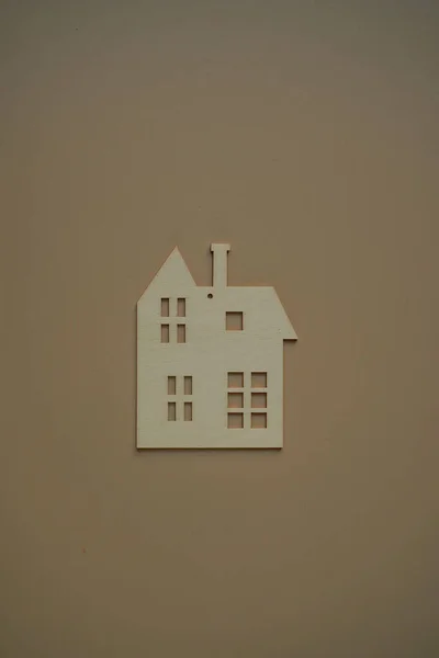 Flat wooden private house on beige background view from above. Home and building insurance. A secure future for your home. Blurred background