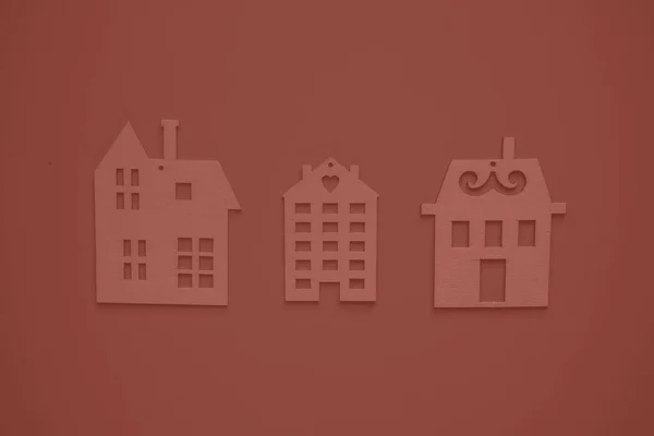Real estate agency. Flat wooden houses on red background view from above. Concept of a creative real estate agency, individual selection of housing
